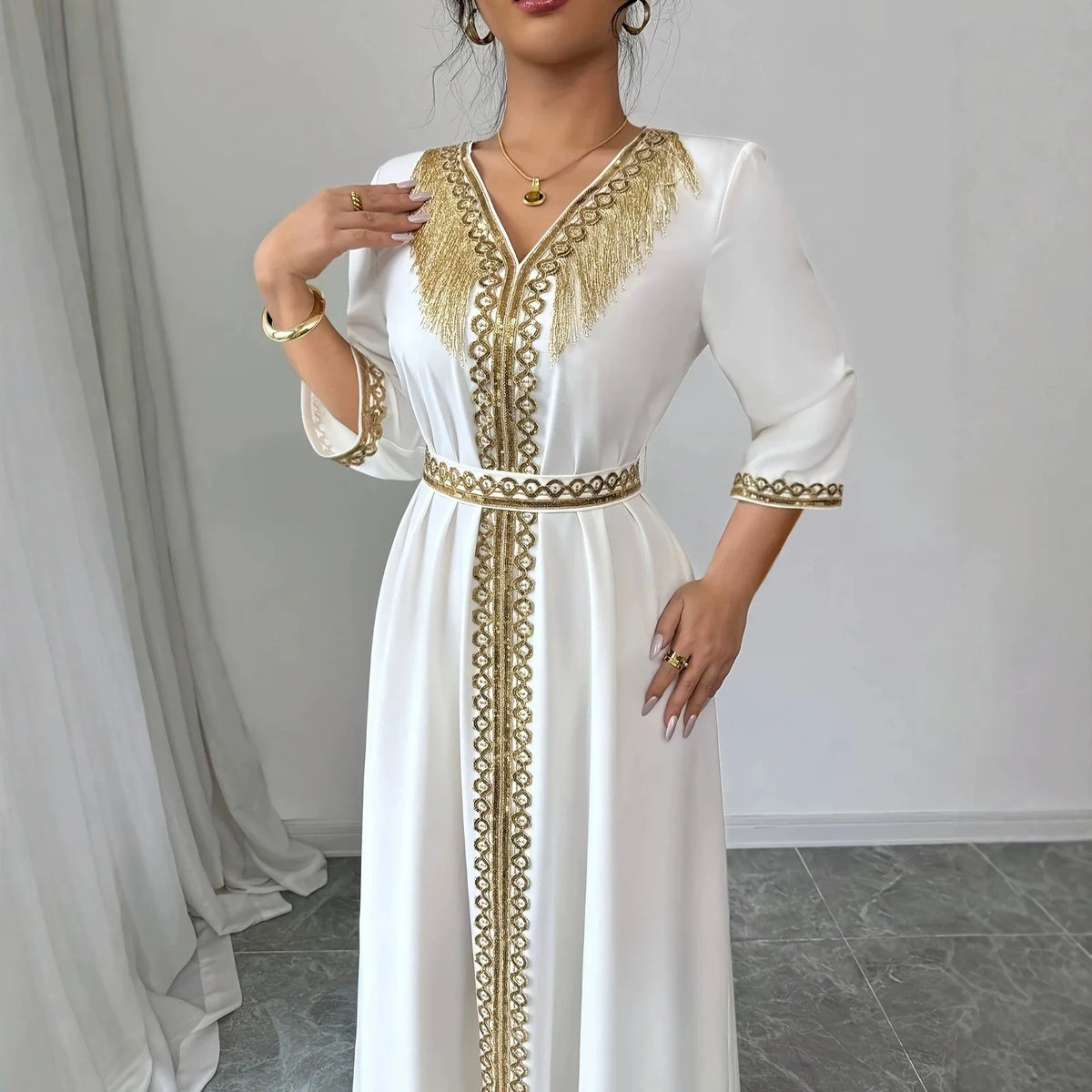 Robe Samira — Détail des broderies géométriques dorées et franges ajourées