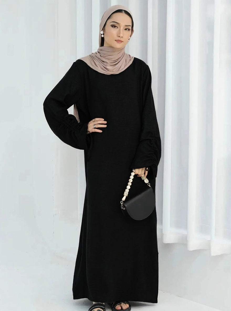 Robe Aïcha noire — vue de face, silhouette kaftan fluide et généreuse